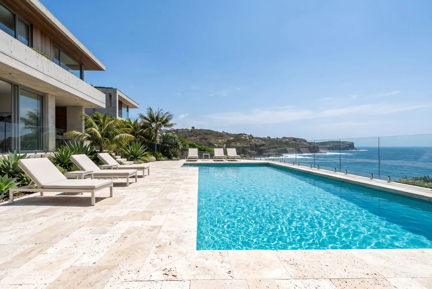 Clean travertine pool surround overlooking the ocean
